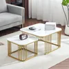 A set of two nesting coffee tables with white marble-look tops and gold metal frames, placed on a rug in a living room setting. Náhľad obrázku produktu