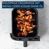 A top-down view of an air fryer basket filled with skewers of food. Produktbild-Vorschau