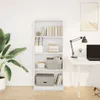A white bookshelf filled with books and storage boxes, placed next to a potted plant and a desk with a laptop and lamp. Náhled obrázku produktu