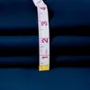 A close-up of a dark blue fabric with a measuring tape on it. Voir les images du produit