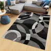 A modern living room with a sectional sofa, a rug, and a blue ottoman. Voir les images du produit