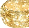 A close-up, coiled view of a string of warm white LED lights on a thin gold wire. Podgląd zdjęcia produktu