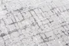 A close-up, angled view of a rug with a textured, abstract geometric pattern in light gray and white. Anteprima dell’immagine prodotto