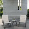 Two chairs and a table on a patio with a concrete wall in the background. Produktbild-Vorschau
