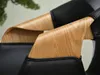 A close-up view of the armrests of a chair, showing the combination of black leather and bent wood. Voir les images du produit