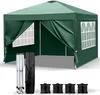 A green pop-up gazebo with four side panels, including two with windows, is shown. Accessories like a folded frame, a carrying bag, and four sandbags are displayed in front of the gazebo. Podgląd zdjęcia produktu