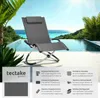 A gray lounge chair is placed on a tiled patio next to a swimming pool with a tropical background. Produktbild-Vorschau