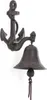 A cast iron anchor-shaped door bell mounted on a white wall. Podgląd zdjęcia produktu