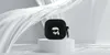 A black AirPods case with a Karl Lagerfeld cartoon character design is displayed on a white pedestal against a backdrop of flowing white fabric. Anteprima dell’immagine prodotto