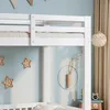 A close-up view of a white bunk bed frame in a child's room, with star-shaped lights on the wall. Voir les images du produit