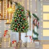 A decorated Christmas tree stands on a staircase landing, surrounded by gifts and festive lights. Podgląd zdjęcia produktu