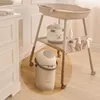 A baby changing station with accessories and a diaper pail. Produktbild-Vorschau
