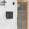 A mailbox with an owl design mounted on a white, clapboard-sided house next to a wooden door. Produktbild-Vorschau