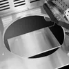 A close-up view of the interior of a stainless steel gas grill, focusing on the burner area and a reflective metal plate. Produktbild-Vorschau
