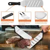 Close-up of spatulas being used on a grill with steaks. Voir les images du produit