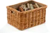 A wicker basket filled with pine cones and branches, presented on a white background. Produktbild-Vorschau