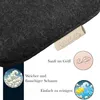 Close-up of a dark gray felt cushion with a brand tag and marketing icons and text. Produktbild-Vorschau