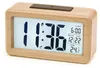 A digital alarm clock with a wooden casing is displayed against a white background. Produktbild-Vorschau