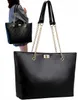 A woman is holding a black tote bag. Náhľad obrázku produktu