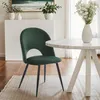 A dark green velvet dining chair is placed next to a white marble-top dining table with a white base. The scene is set in a well-lit room with wooden floors and a rug. Anteprima dell’immagine prodotto