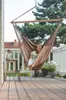 A woman relaxing in a hammock chair on a wooden deck. Produktbild-Vorschau