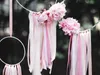 Decorative hoops with pink flowers and ribbons hanging outdoors. Podgląd zdjęcia produktu