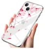 A hand holding an iPhone 14 with a clear case featuring a pink floral pattern. Produktbild-Vorschau