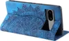 A blue flip case for a Google Pixel 8a phone, with an embossed mandala pattern, is shown in a studio setting. Produktbild-Vorschau