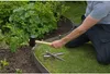 A person is installing garden edging around a flower bed. Produktbild-Vorschau