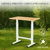 A height-adjustable desk is placed in a natural outdoor setting with trees and grass. Voir les images du produit