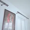 A room interior with a framed picture of a lion and two double curtain rods mounted on the wall above a window with blinds. Podgląd zdjęcia produktu