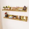 Two wooden shelves mounted on a white wall, decorated with various items. Voir les images du produit