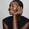 A woman wearing a black shirt and a bracelet with charms. Anteprima dell’immagine prodotto