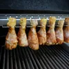 Chicken drumsticks seasoned and placed on a grill rack. Podgląd zdjęcia produktu