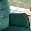 A close-up view of a dark green corduroy armchair next to a window with a view of greenery outside. A small wooden table with a cup and saucer is also visible. Anteprima dell’immagine prodotto