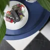 A close-up shot of a set of keys on a small decorative plate, placed on a blue tray. Produktbild-Vorschau