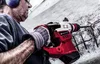A man is using a hammer drill to break concrete. Podgląd zdjęcia produktu