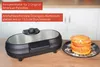 Pancake-Make auf Holztheke, daneben Teller mit goldenen Pfannkuchen, rotes Etikett zeigt Funktionen Produktbild-Vorschau