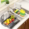 A kitchen sink with an adjustable drying rack filled with fruits and cleaning supplies. Produktbild-Vorschau