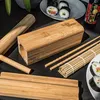 A collection of bamboo sushi-making tools and finished sushi rolls. Náhľad obrázku produktu