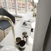 A vanity table with makeup and magazines, next to a window. Náhled obrázku produktu