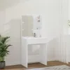 A white vanity table with a mirror and shelves is shown in a room with a plant and white curtains. Voir les images du produit