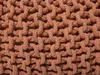 A close-up view of a knitted pouf made of thick, braided rope. Produktbild-Vorschau