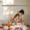 A woman and a child are sitting on the floor with a knitting machine and balls of yarn. Náhled obrázku produktu