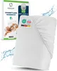 A white fitted sheet is shown diagonally, with a product box in the background. Water splashes are depicted around the sheet. Náhled obrázku produktu