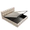 A beige upholstered bed frame with the mattress support system lifted to reveal storage space underneath. Náhľad obrázku produktu