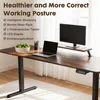 A modern adjustable height desk with a laptop, monitor, and a bowl of limes. Produktbild-Vorschau