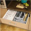 An open kitchen drawer containing cutlery and a tea towel. Produktbild-Vorschau