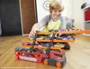A young boy is playing with a Hot Wheels Mega-Truck filled with toy cars. Náhled obrázku produktu