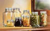 A collection of glass jars filled with various preserved foods, arranged on a wooden surface. Produktbild-Vorschau